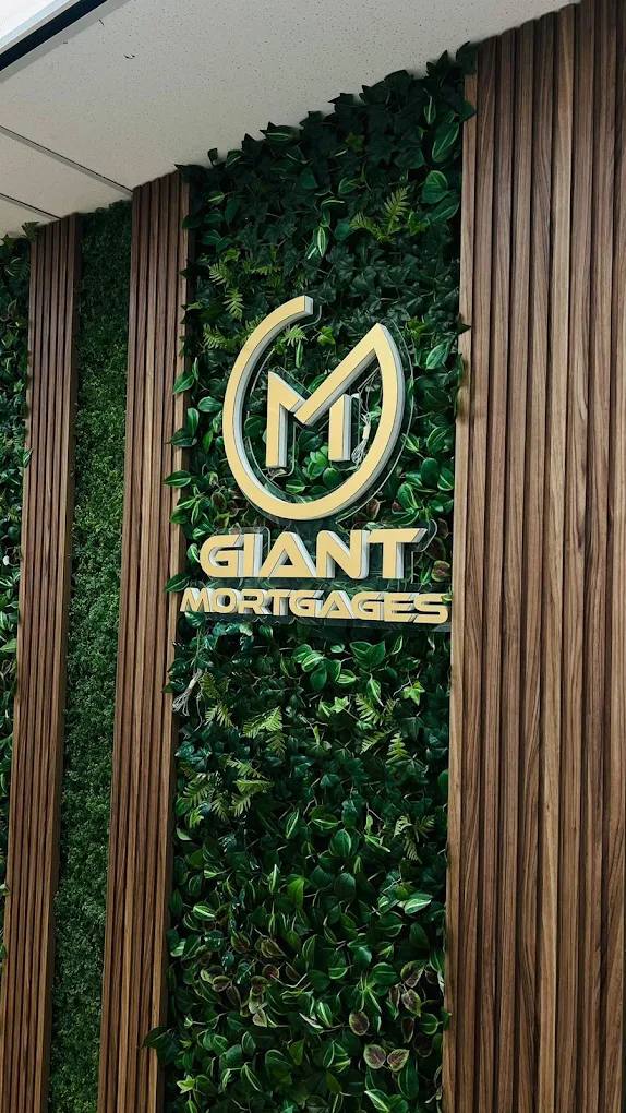 Gold Giant Mortgages dimensional logo sign mounted on a green living wall between wood slats