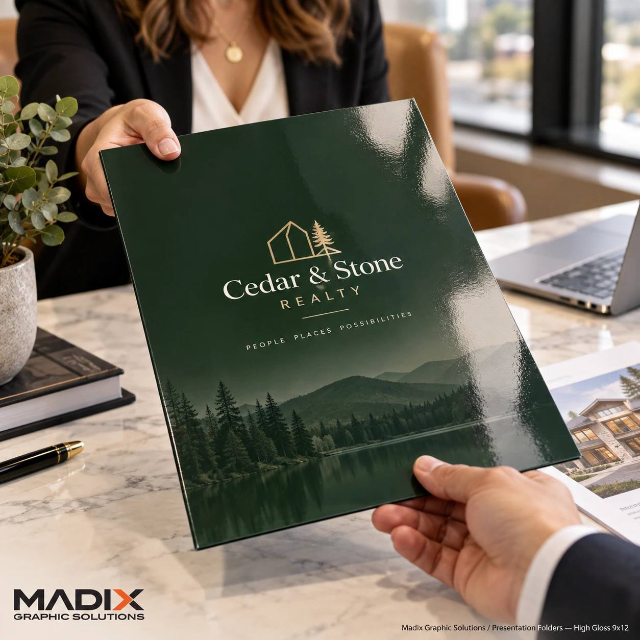High-gloss green presentation folder for Cedar & Stone Realty being handed across a desk, printed by Madix