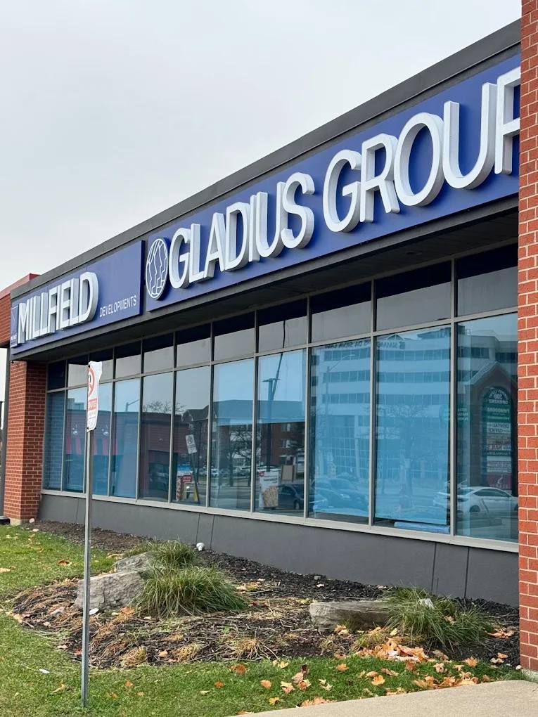 Blue storefront fascia signs with white dimensional letters for Millfield Developments and Gladius Group